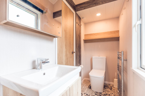 Bagno luminoso in una tiny house presso Holiday park Ackersate, Paesi Bassi, con lavabo e servizi igienici.