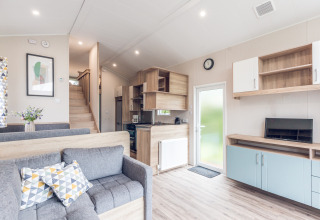 Interior luminoso y moderno de una tiny house lodge en Holiday Park Ackersate, Países Bajos, con cocina.