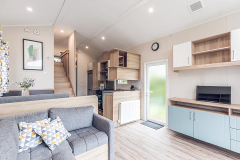 Bright and modern interior of a tiny house lodge at Holiday Park Ackersate, Netherlands, with kitchen.