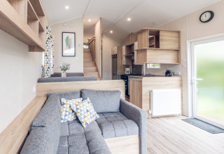 Soggiorno moderno e compatto con cucina in una tiny house all’Holiday park Ackersate, Paesi Bassi.