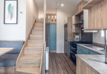 Interior moderno de tiny house en Holiday park Ackersate, Países Bajos, con cocina, escalera y comedor.