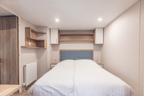 Camera da letto in una tiny house all’Holiday park Ackersate nei Paesi Bassi con letto matrimoniale moderno.