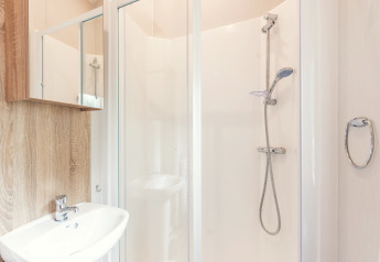Salle de bain moderne avec douche, lavabo et miroir dans une Tiny House au Holiday park Ackersate, Pays-Bas.