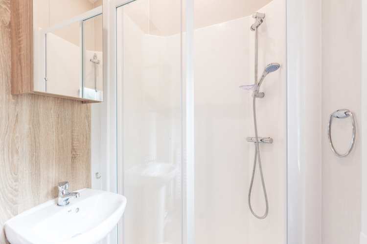 Baño moderno con ducha, lavabo y espejo en una Tiny House en Holiday park Ackersate, Países Bajos.