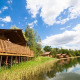 Water Lodge presso Holiday Park BreeBronne, Paesi Bassi, su palafitte accanto al lago sotto cielo azzurro.