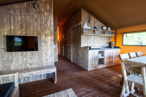 Innenaufnahme der Water Lodge WL im Holiday Park BreeBronne mit Holzmöbeln und Küchenbereich.