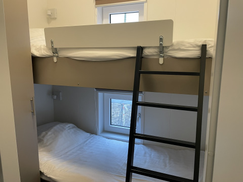 Foto di un letto a castello in una Wood Cottage a Holiday park De Witte Berg, Paesi Bassi, con finestre.