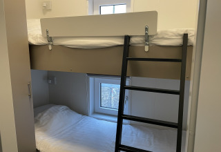 Foto de una litera en una Wood Cottage en Holiday park De Witte Berg, Países Bajos, con ventanas visibles.