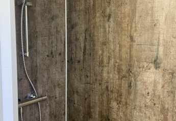 Douche aux murs effet bois dans le Wood Cottage du Holiday park De Witte Berg, aux Pays-Bas.