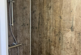 Shower with wood-look walls in the Wood Cottage at Holiday park De Witte Berg in the Netherlands.