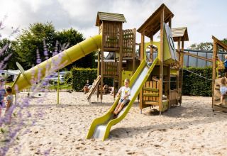 Kinderen spelen op een speeltuin met glijbaan bij Wood Cottage, Vakantiepark De Witte Berg, Nederland.