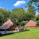 Twee Glamptent GT tenten en picknicktafels bij Holiday Park BreeBronne in Nederland op een zonnige dag.