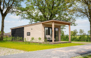 Wellness Lodge med jacuzzi og sauna i Vakantiepark Hölter, Holland, omgivet af grønne områder og natur.