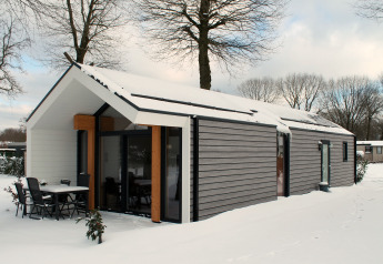 Ecovilla-lodge i Holiday park Ackersate, Nederlandene, viser sneklædt tag og moderne facade.