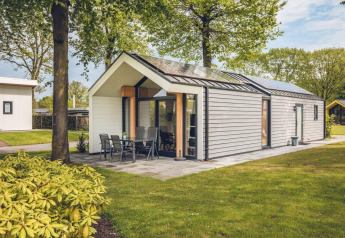 The eco-friendly Ecovilla lodge at Holiday Park Ackersate in the Netherlands, surrounded by green trees.