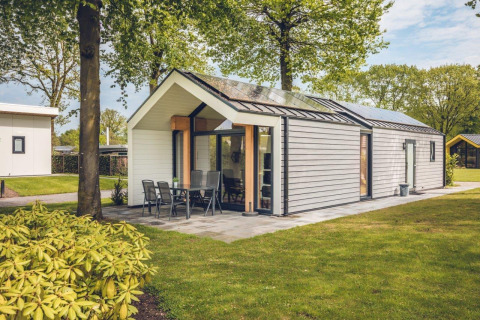De milieuvriendelijke Ecovilla-lodge op Vakantiepark Ackersate in Nederland, omgeven door groene natuur.