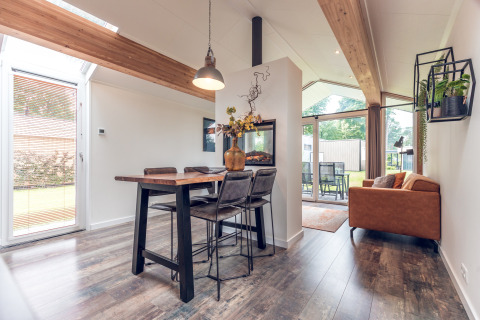 Moderne Ecovilla lodge op Vakantiepark Ackersate in Nederland, lichte inrichting met eet- en zitgedeelte.