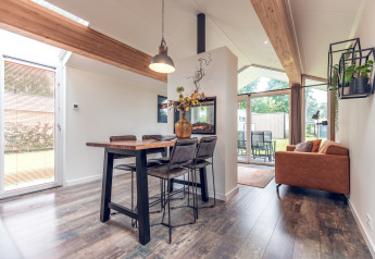 Moderne Ecovilla lodge op Vakantiepark Ackersate in Nederland, lichte inrichting met eet- en zitgedeelte.