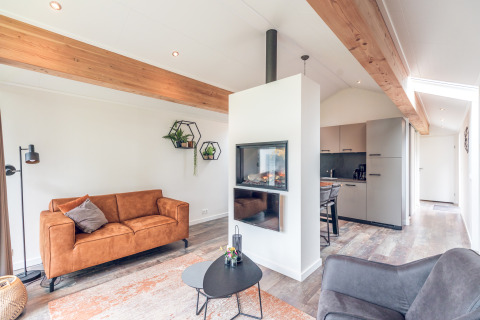 Moderne, lichte lodge in Ecovilla bij Vakantiepark Ackersate, Nederland, met woonkamer en keuken.