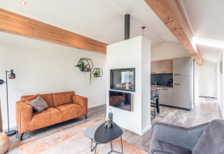 Moderne, lichte lodge in Ecovilla bij Vakantiepark Ackersate, Nederland, met woonkamer en keuken.