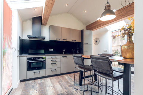 Cucina e zona pranzo moderne in Ecovilla presso Holiday park Ackersate, con interni eleganti e luminose finestre.