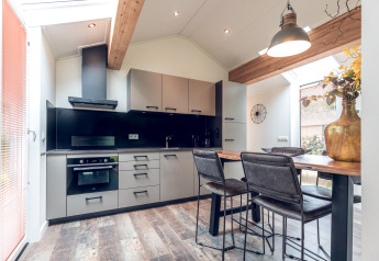 Cucina e zona pranzo moderne in Ecovilla presso Holiday park Ackersate, con interni eleganti e luminose finestre.