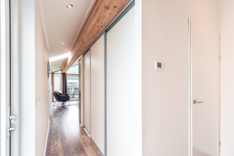 Corridoio luminoso in Ecovilla al Holiday park Ackersate, Paesi Bassi, con dettagli in legno e arredi moderni.