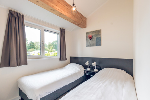 Habitación con dos camas individuales, ventana grande, decoración moderna en Ecovilla, Holiday Park Ackersate.