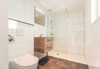 Salle de bain moderne à Ecovilla, Holiday park Ackersate, Pays-Bas, avec douche à l'italienne et meuble bois.