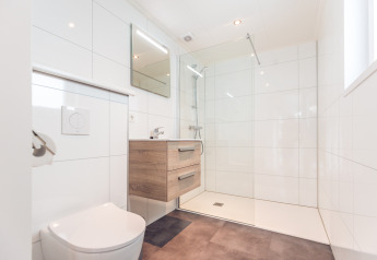 Bagno moderno nell’Ecovilla al Holiday park Ackersate, Paesi Bassi, con doccia e mobile lavabo in legno.