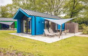 Chalet de caza azul con sauna y terraza exterior en Holiday park Ackersate, rodeado de naturaleza en Países Bajos.