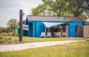 Moderno chalet de caza con sauna en Holiday park Ackersate, Países Bajos, rodeado de vegetación y césped.