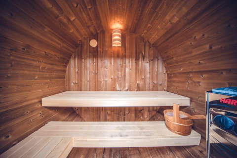 Vista interior de la sauna en el chalet de caza en Holiday park Ackersate, Países Bajos, con bancos de madera.