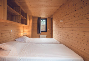 Camera da letto in legno con due letti singoli in un accogliente chalet da caccia con sauna all'Holiday park Ackersate, Paesi Bassi.