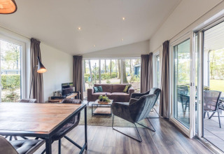 Lichte woonkamer in Forest Villa op Holiday park Ackersate in Nederland met moderne inrichting en tuinzicht.