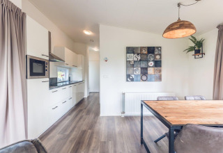 Cucina moderna e zona pranzo nella Forest Villa all’Holiday park Ackersate, Paesi Bassi, arredamento chiaro.