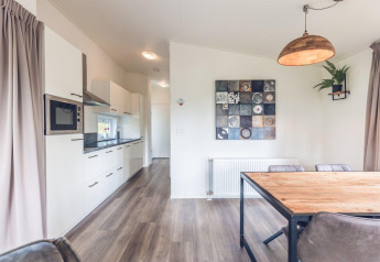 Cucina moderna e zona pranzo nella Forest Villa all’Holiday park Ackersate, Paesi Bassi, arredamento chiaro.