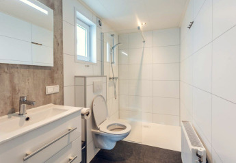 Salle de bains moderne avec toilettes, lavabo et douche à Forest Villa, Holiday park Ackersate, Pays-Bas.