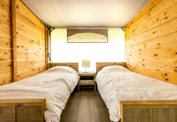 Interior de Tentvilla con dos camas individuales en el parque vacacional De Witte Berg, Países Bajos.