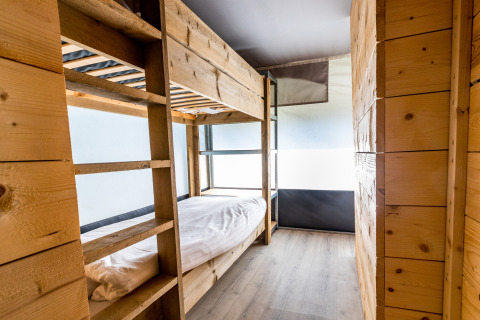 Interieur van een safaritentvilla met houten stapelbedden in vakantiepark De Witte Berg in Nederland.