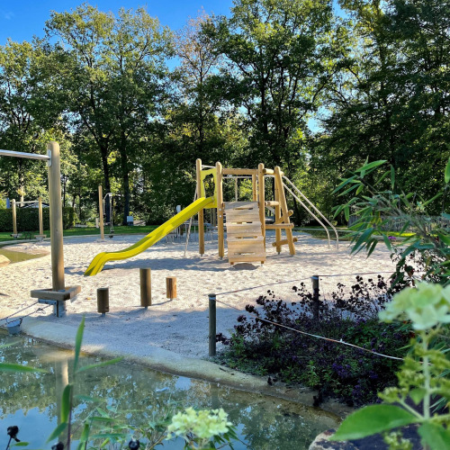 Parque infantil con estructura de madera y tobogán amarillo en la Tentvilla del parque De Witte Berg, Países Bajos