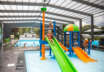 Des enfants jouent sur un toboggan coloré dans la piscine couverte à Holiday park De Witte Berg, Pays-Bas.