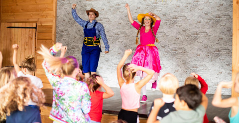 Kinderen genieten van een voorstelling met twee verklede artiesten op het podium van Tentvilla, De Witte Berg.