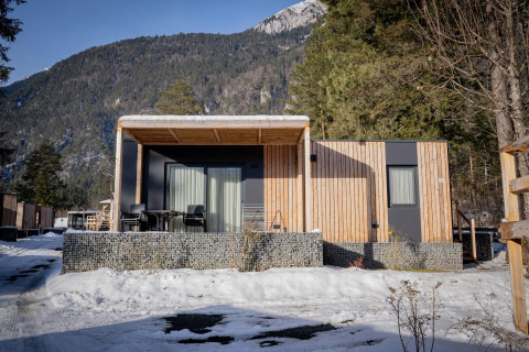 Chalet moderne de Wulfenia au Pressegger See, Autriche, en hiver avec montagnes enneigées au fond.