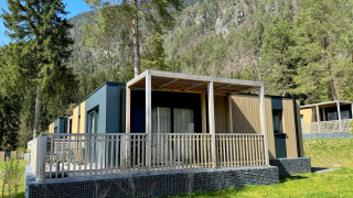 Vue extérieure du lodge moderne Wulfenia, entouré d’arbres et de montagnes dans un cadre pittoresque.