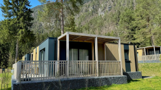 Vue extérieure du lodge moderne Wulfenia, entouré d’arbres et de montagnes dans un cadre pittoresque.