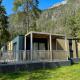 Udendørsbillede af en moderne lodge ved navn Wulfenia, omgivet af træer og bjerge i smuk natur.
