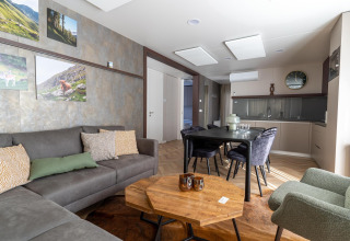 Moderne woonkamer en eethoek in de Wulfenia lodge bij Pressegger See, Oostenrijk, met kunst aan de muur.