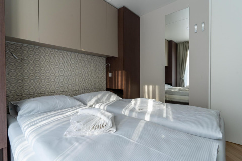 Moderne slaapkamer in Wulfenia bij Pressegger See, Oostenrijk, met twee bedden en lichte inrichting.