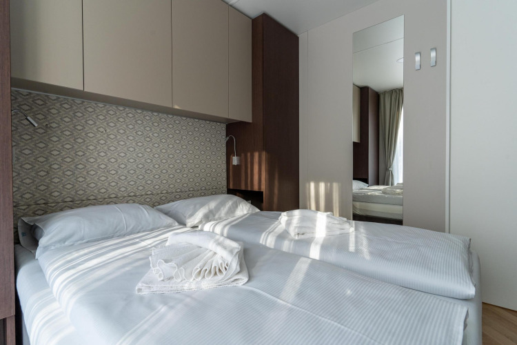 Moderne slaapkamer in Wulfenia bij Pressegger See, Oostenrijk, met twee bedden en lichte inrichting.